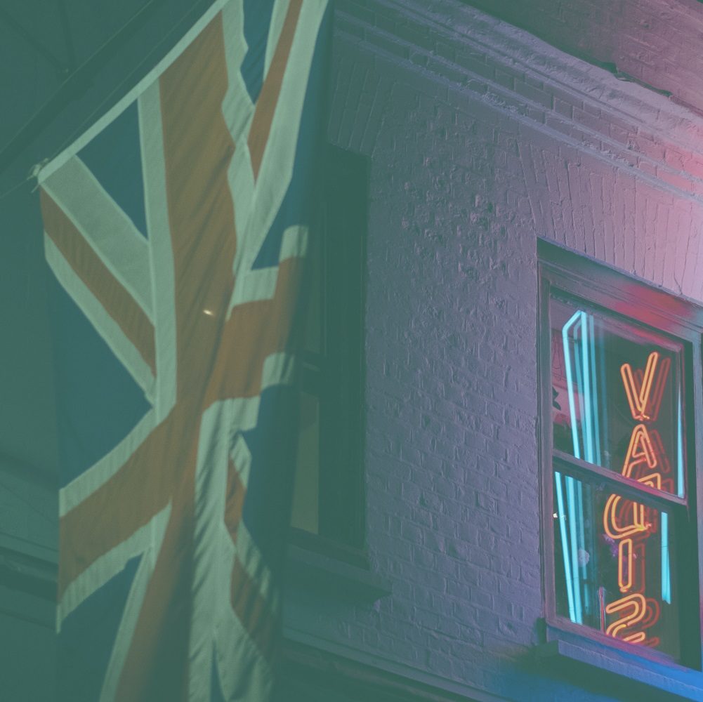 Union Jack hanging at a house with neon sign sying "quo vadis"